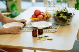 Woman at a table with medication and healthy wellness treatment.